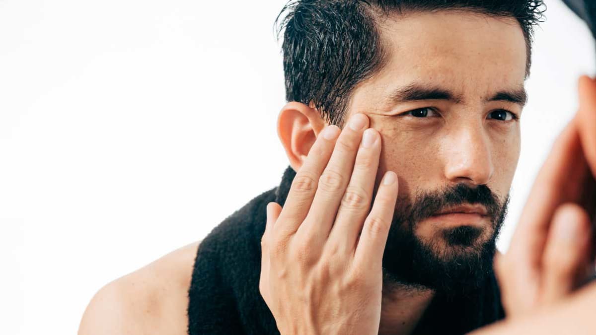 Man looking at face in mirror