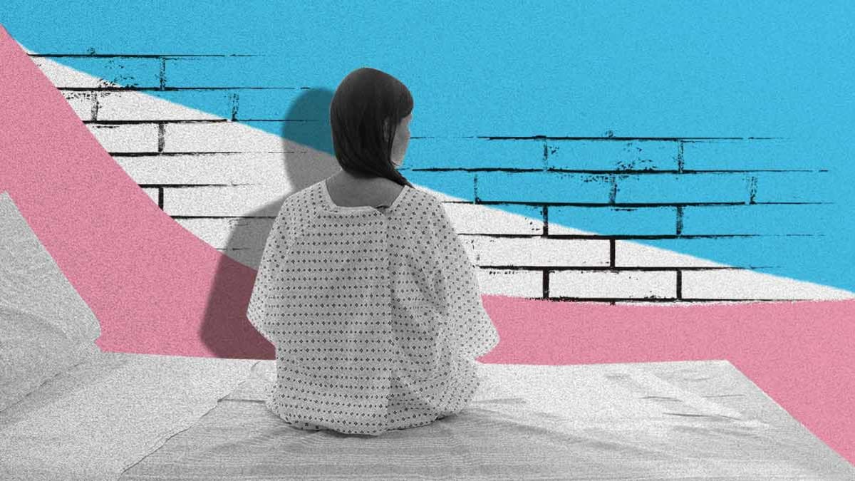 A Transgender Woman sits in a hospital gown on a hospital bed. In front of her is an illustration of a brick wall with the color of the Transgender flag.