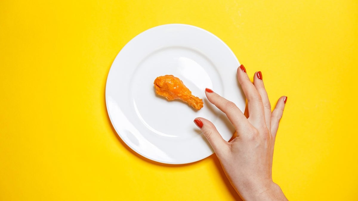 hand picking up chicken wing