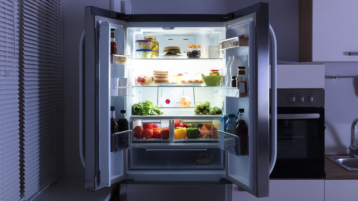 Open refrigerator door in a dark kitchen