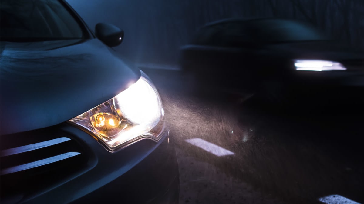 Cars at night on a road with their headlights on