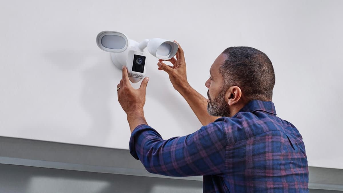 Person installing a Ring Floodlight security camera.