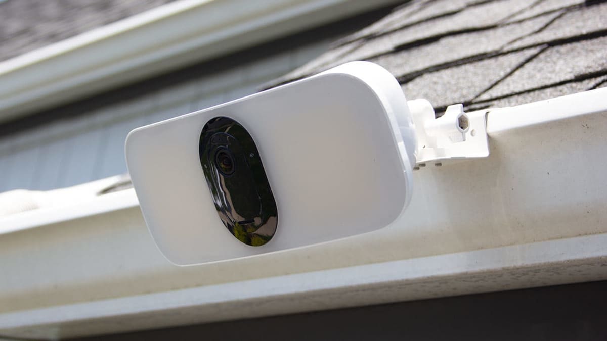 Arlo floodlight camera attached to a garage roof.