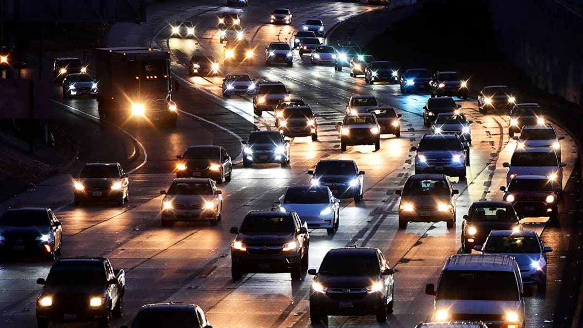 Cars driving on a highway at night.