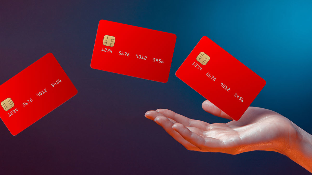 Hand floating in a space with three credit cards floating out of the hand.