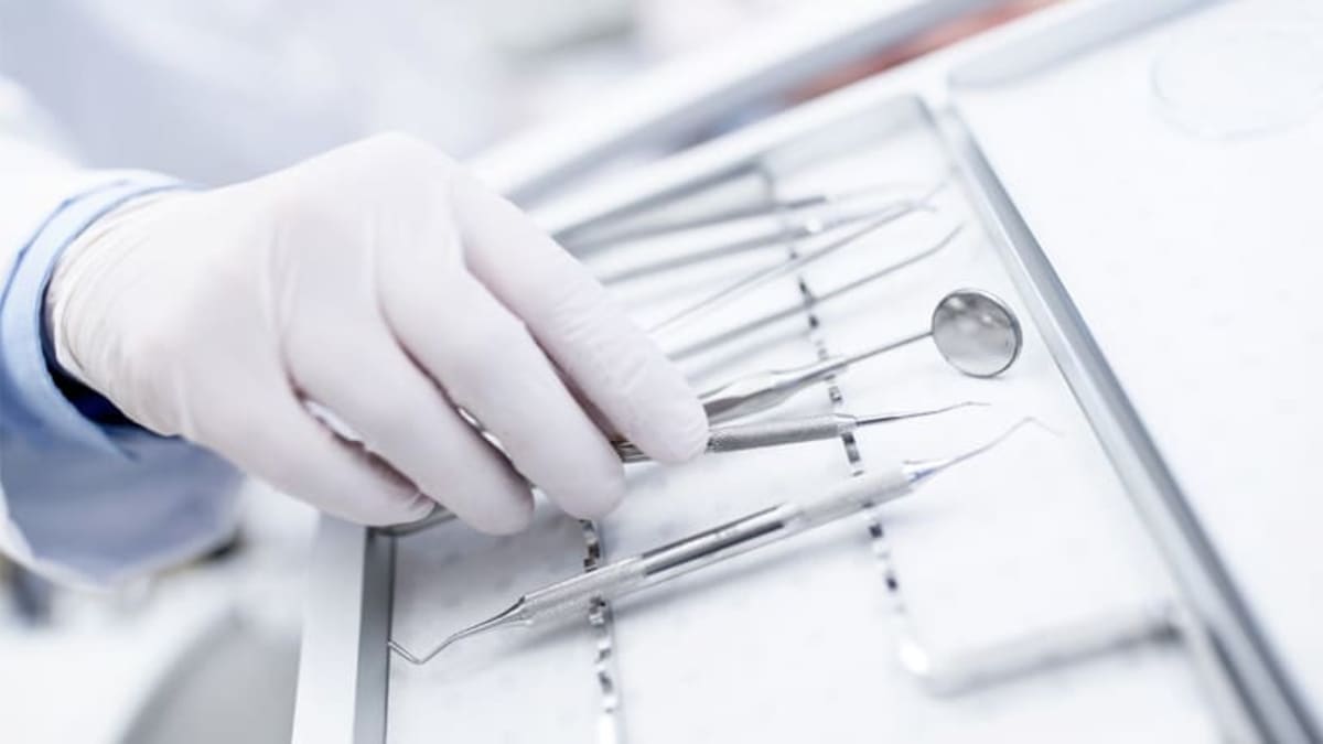 Dentist hand with dental tools in dentist office