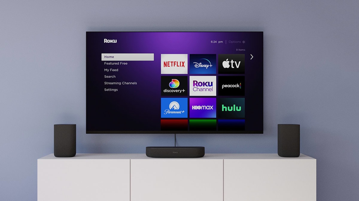 Wall mounted TV showing Roku interface, Roku speakers and Roku streambar on console table