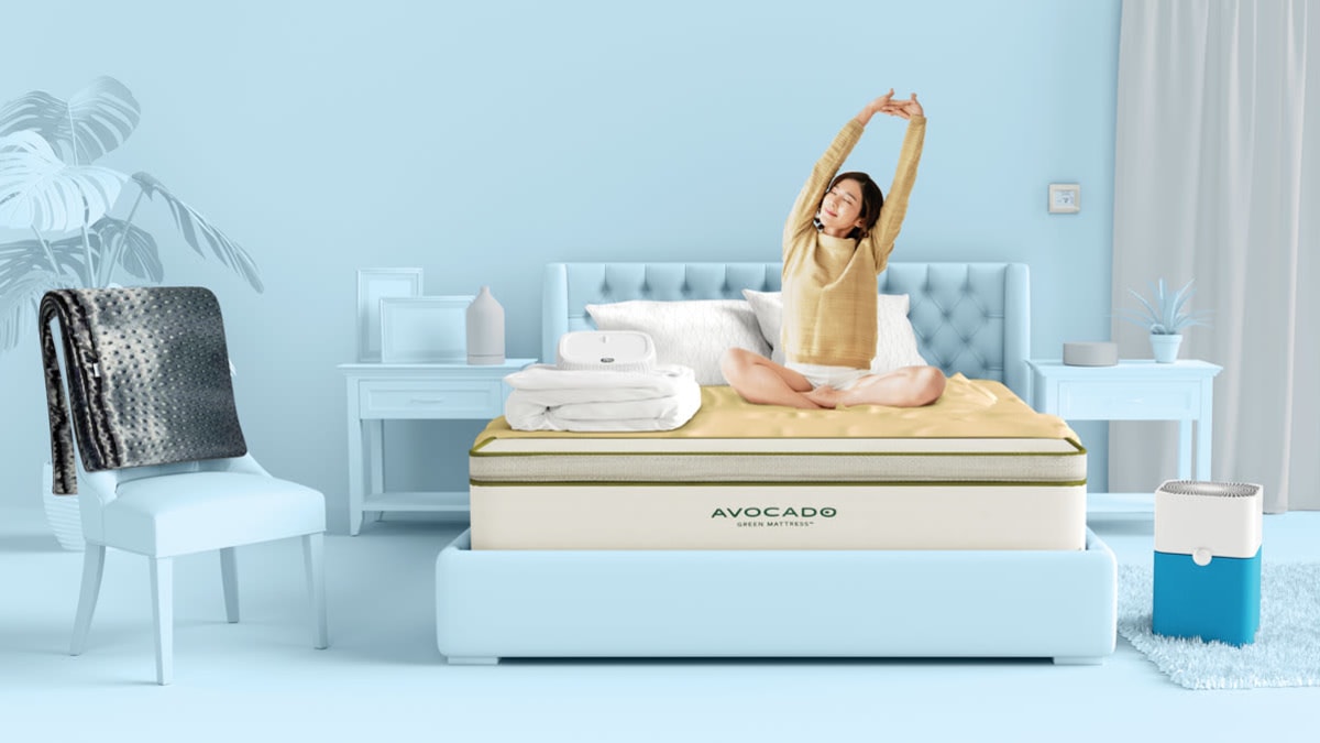 Women on avocado mattress surrounded by products to help her get a better nights sleep