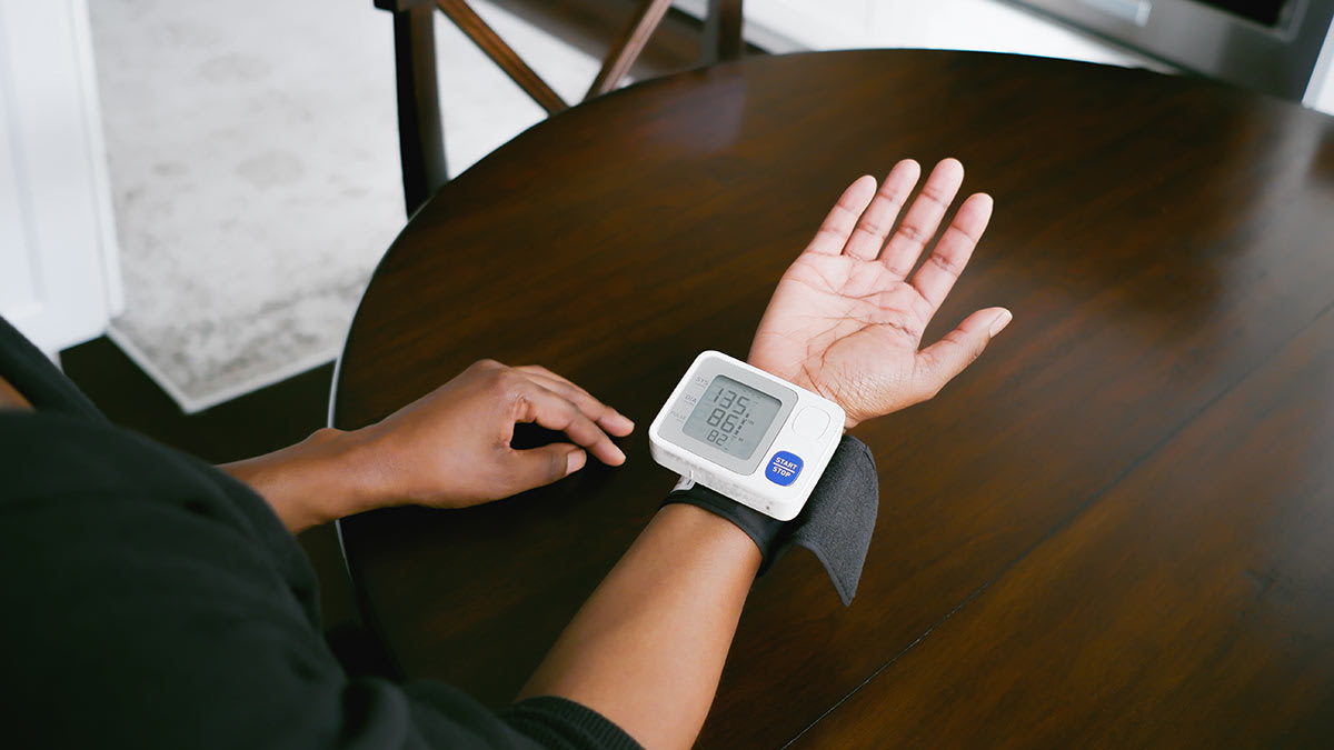 Person wearing a wrist cuff blood pressure monitor.