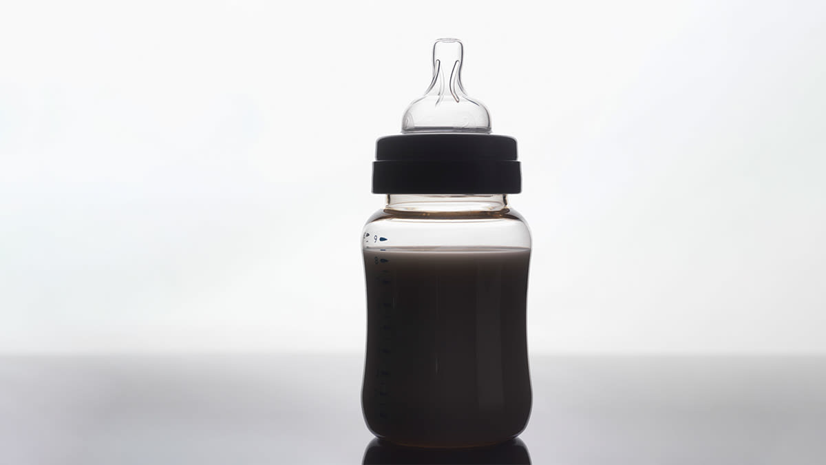 A baby bottle seen in shadow.
