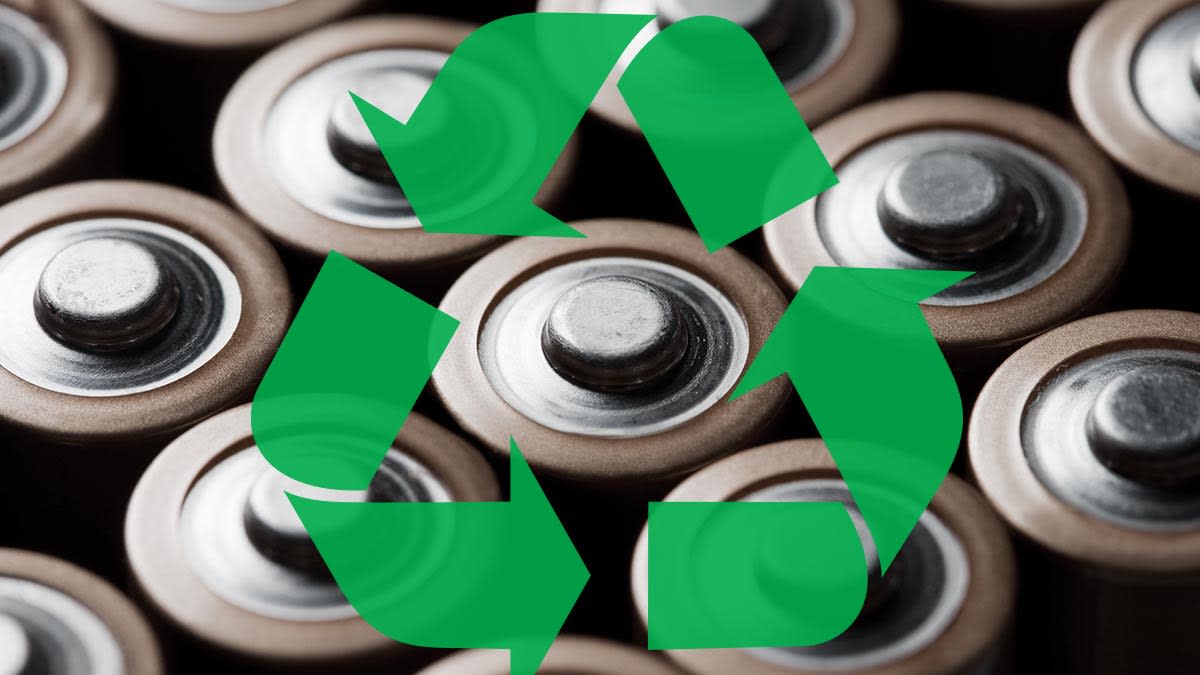 Closeup of batteries with the recycling symbol placed over it.
