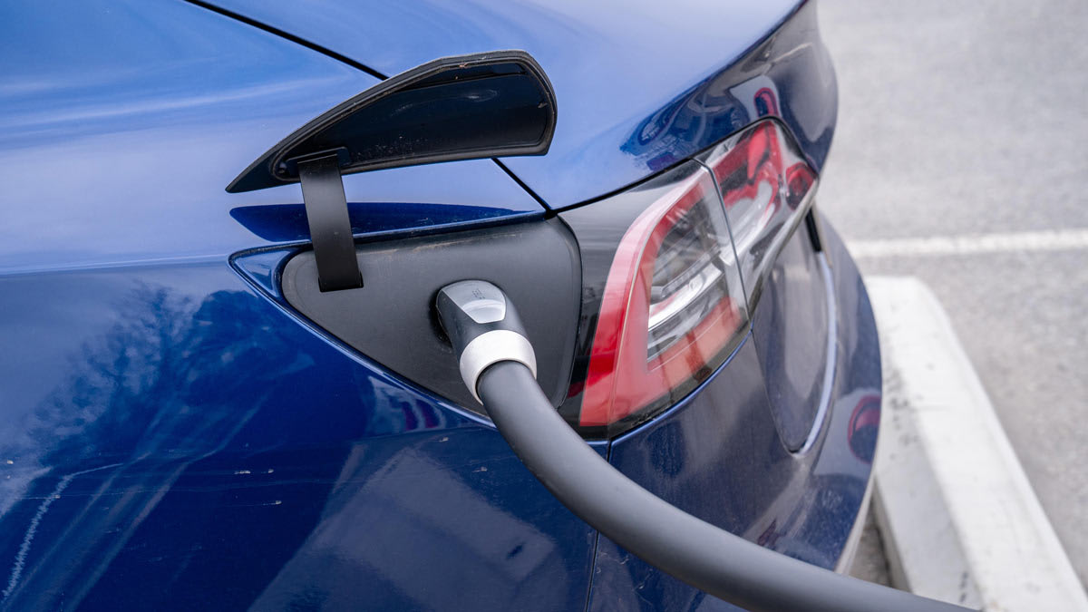 A Tesla electric car is plugged into a recharging terminal