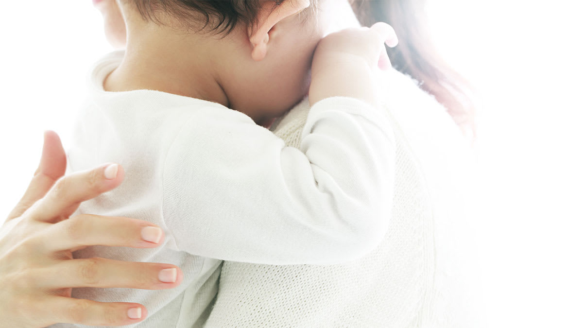 Baby being held by their parent.