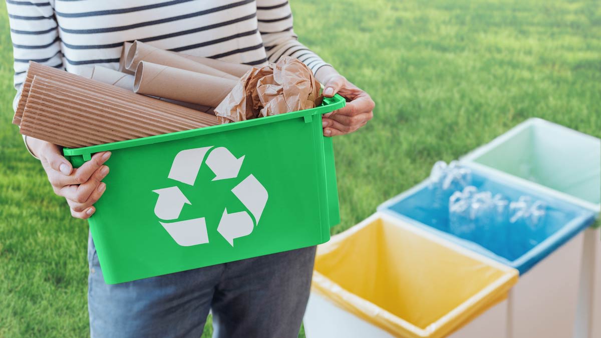 Person sorting paper waste to proper recycling bin