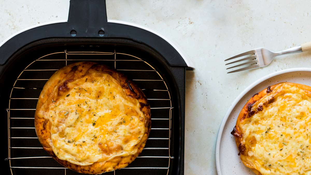Cheese Pizza Margherita in air fryer and one pizza on plate with fork