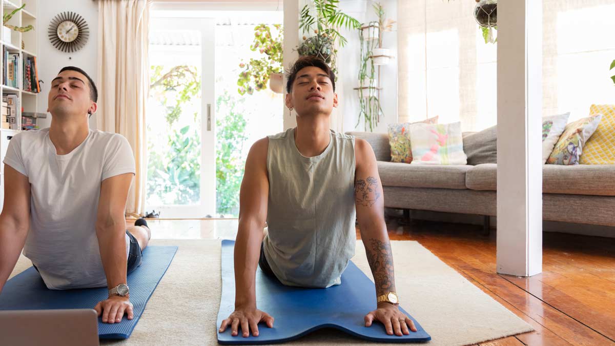 couple doing yoga on blue yoga mats in living room