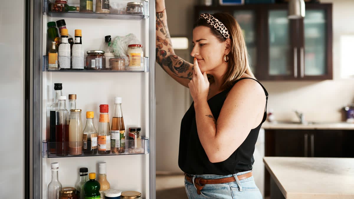 Woman looking inside a refrigerator at home