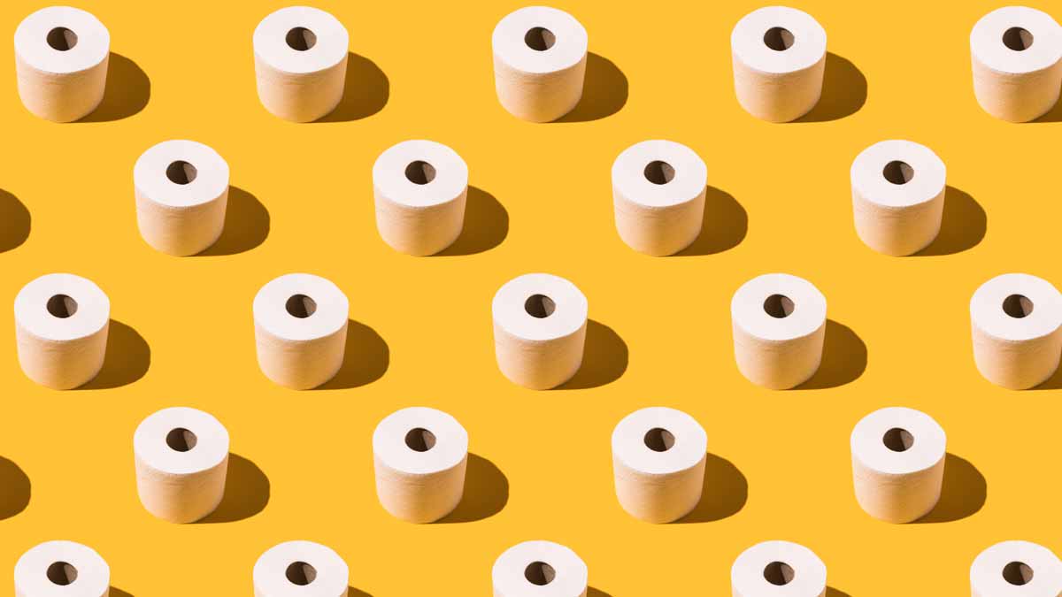 rows of toilet paper rolls on yellow background