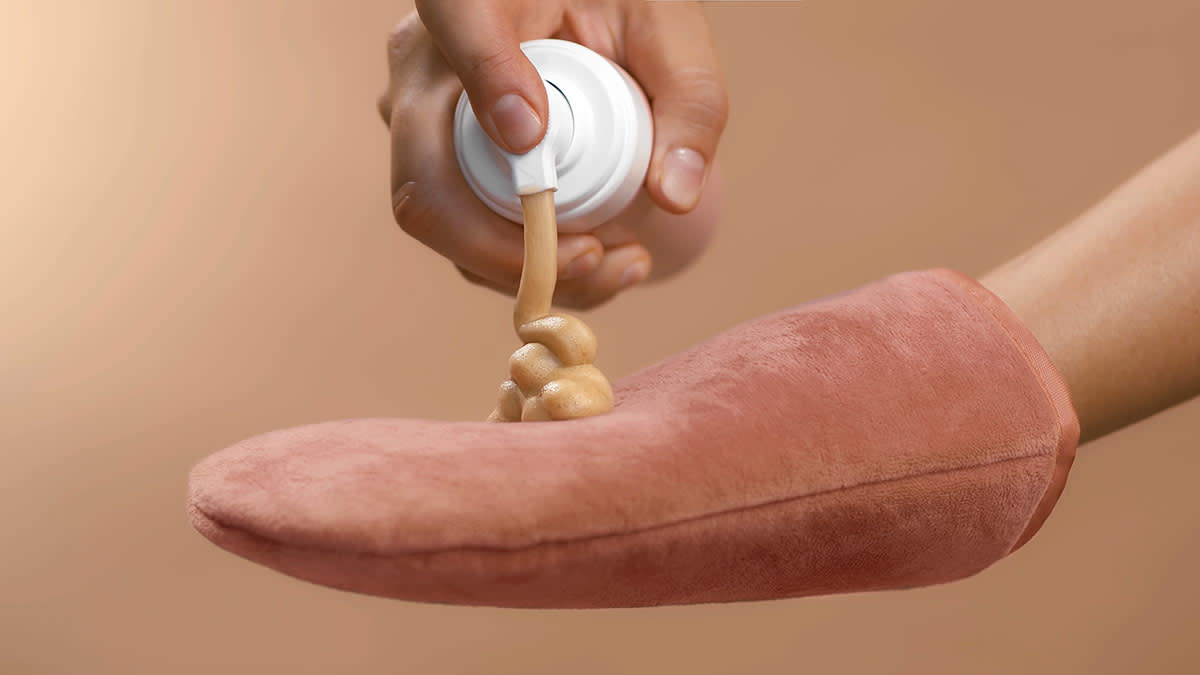 person pumping self tanning lotion onto a cloth glove