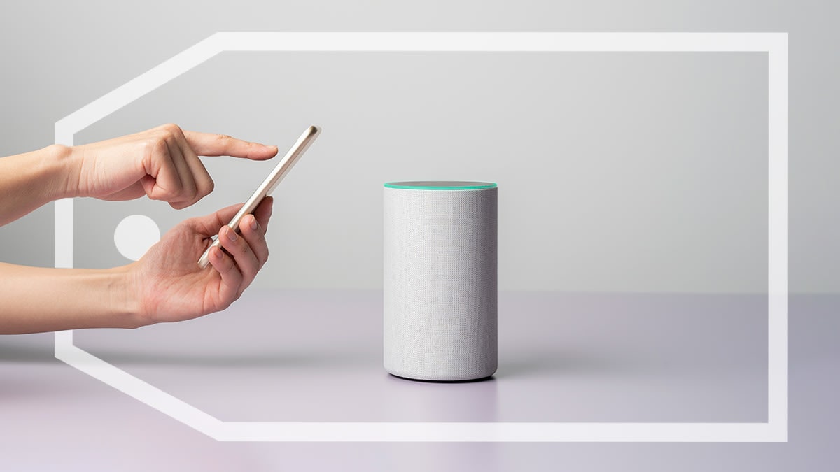 Person using their cell phone to control a smart speaker and a large sales tag