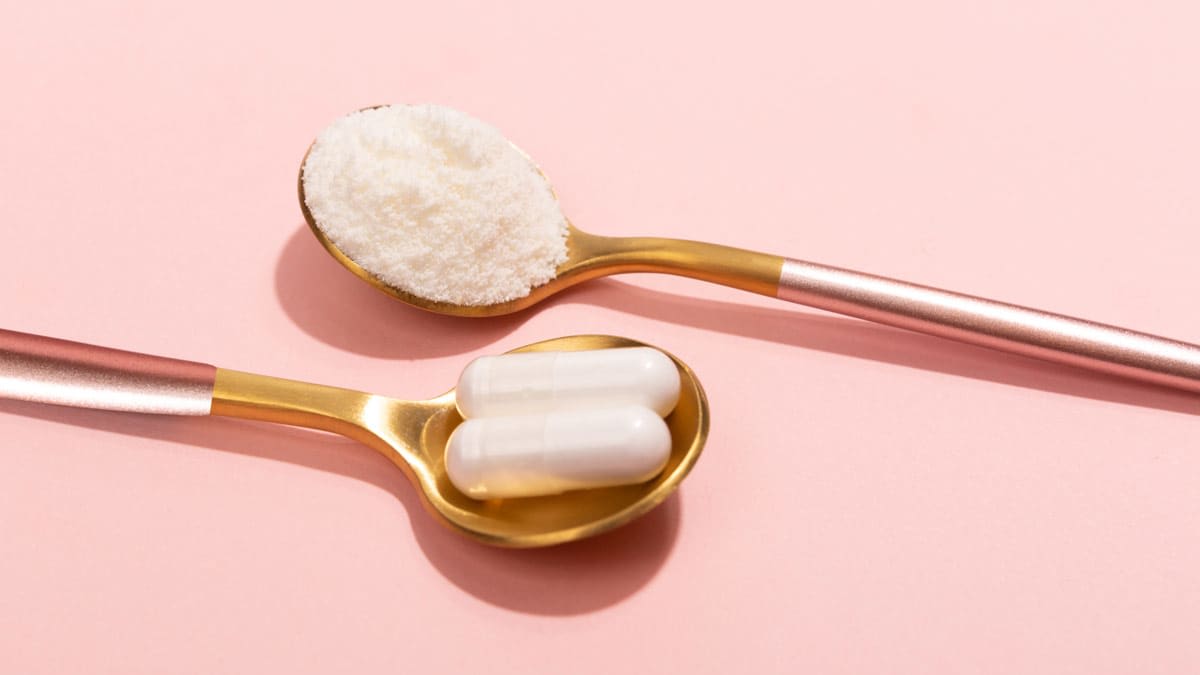 two spoons with different forms of collagen, one with 2 pills and one with a powder