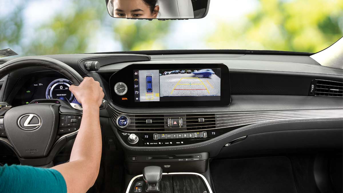 Person in a 2022 Lexus LS 500h with Rear Cross Traffic Alert on the screen