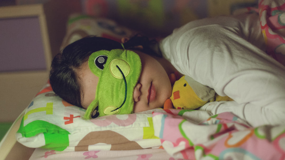 Child sleeping with an eye mask.