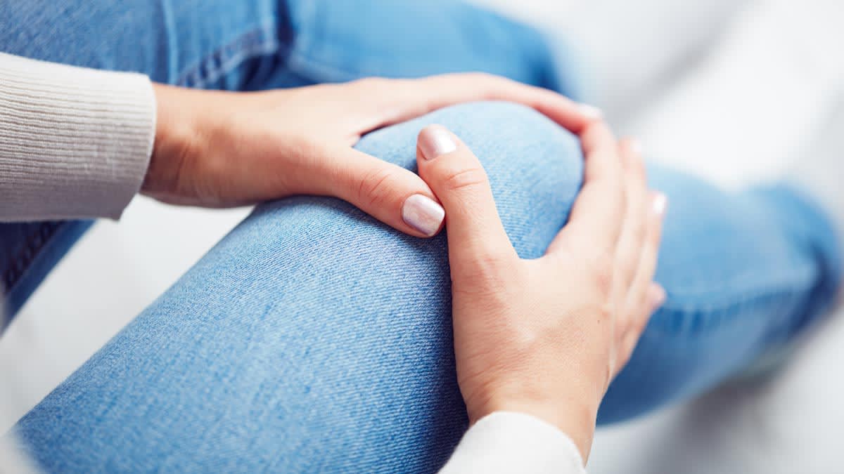woman holding painful knee