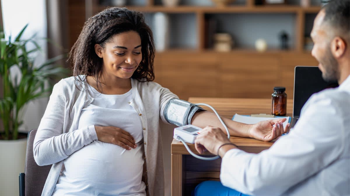 A pregnant woman getting her blood pressure taken at the Doctors Office