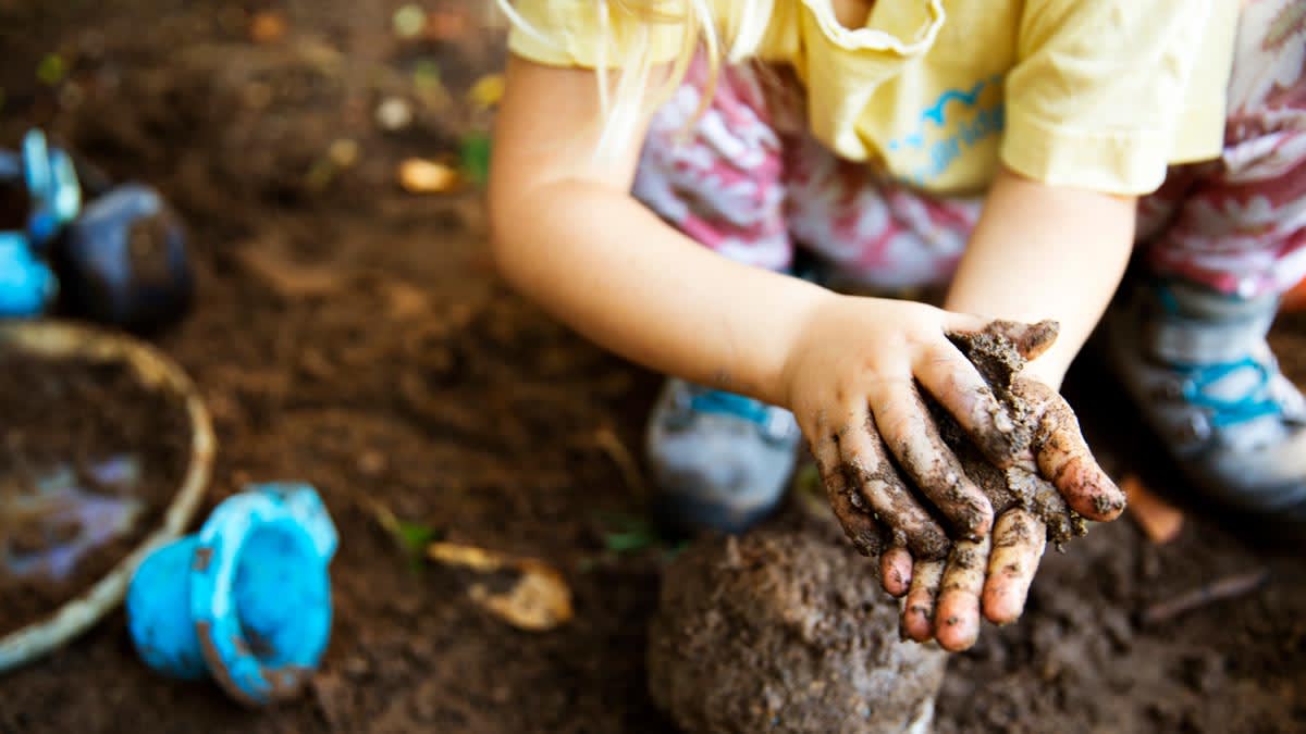 girl playing with mud