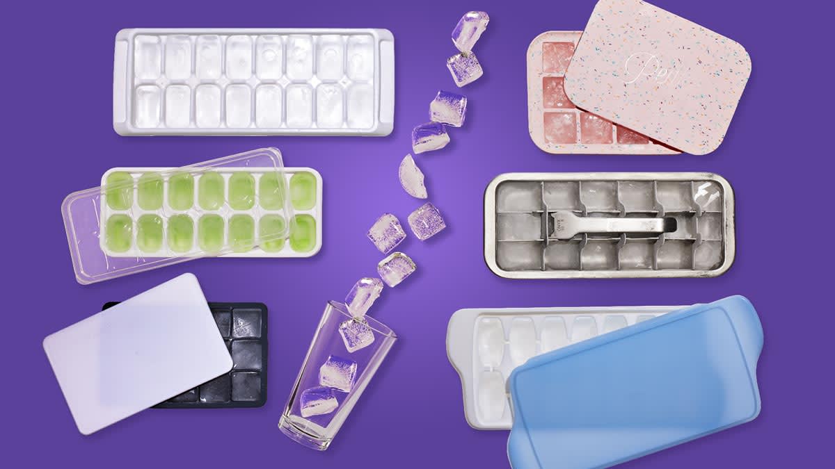 six ice cube trays and a glass spilling ice
