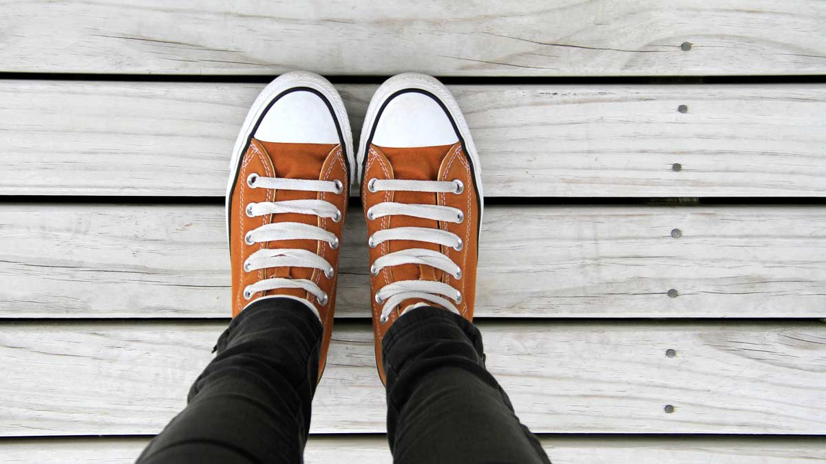first person's view of legs and feet on aged wooden decking