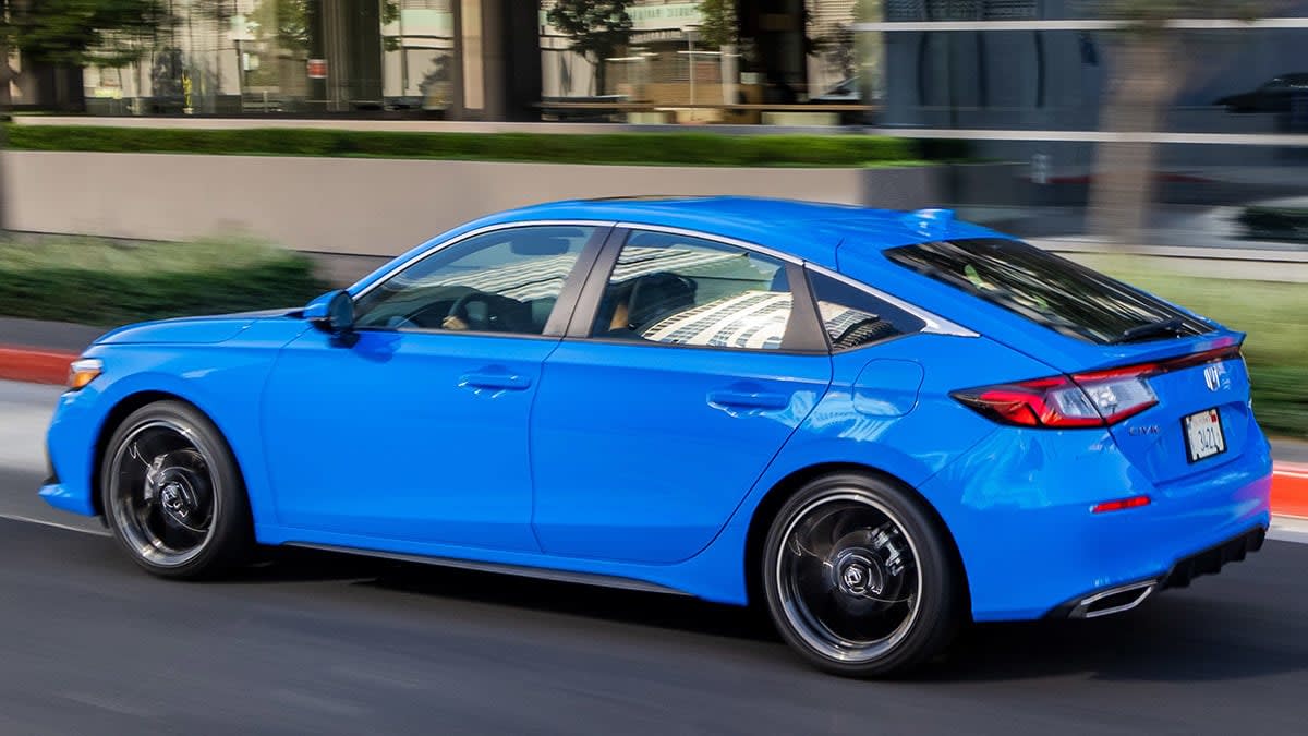 2022 Honda Civic hatchback, rear, driving in a city.