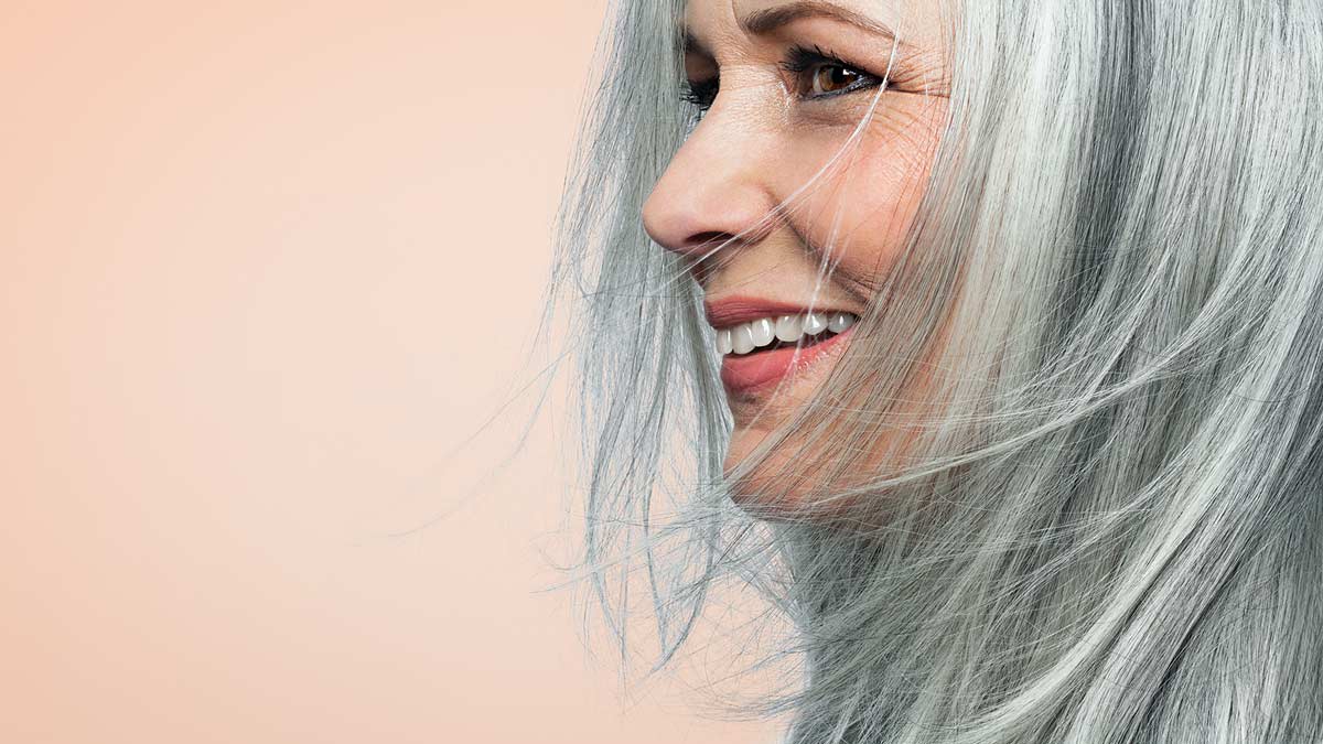 profile view of smiling person with grey hair