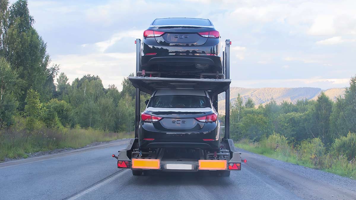 Cars stacked in a transport vehicle on the road.