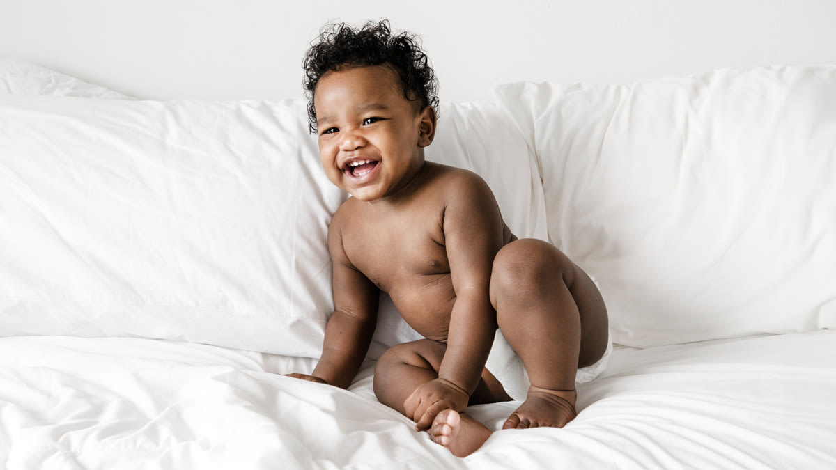 A smiling toddler wearing training pants