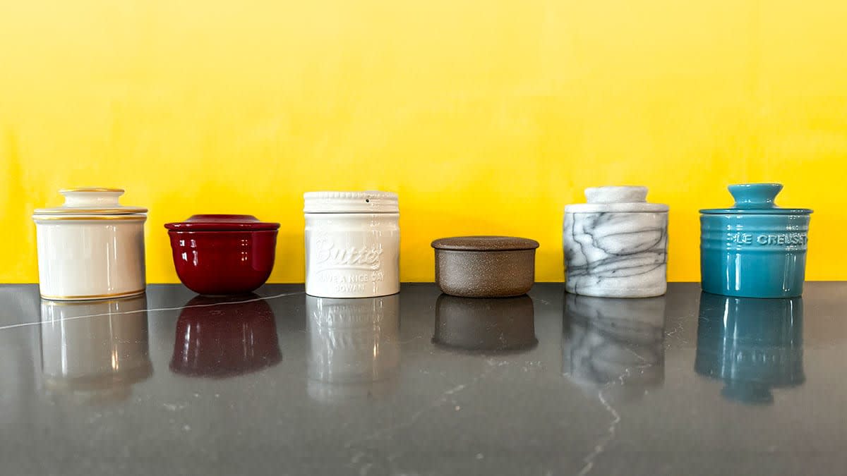 Butter crocks on a kitchen counter against a yellow wall