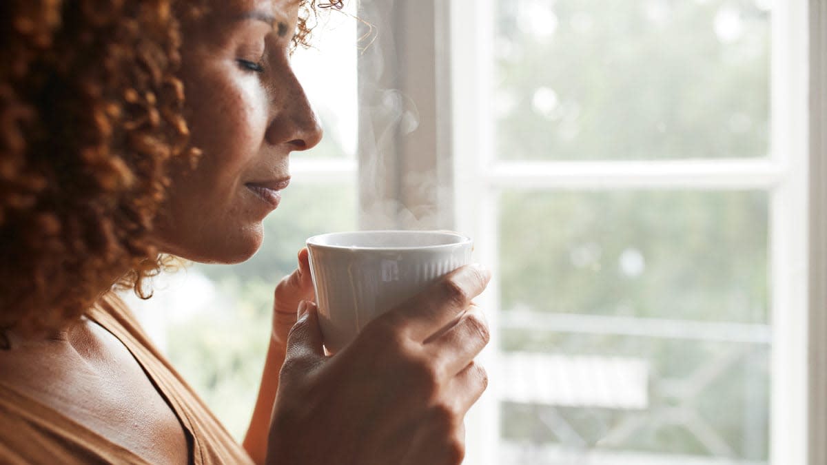 A woman holding a hot beverage