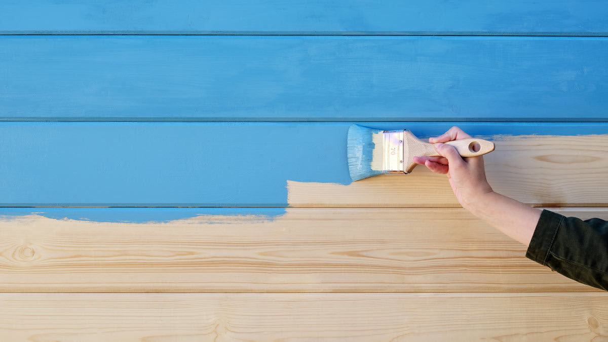 a person painting a wall blue