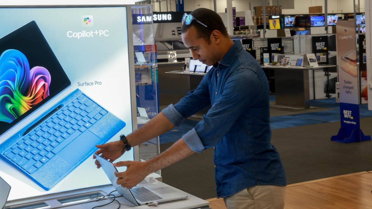 Carlos Tuiz looks at a laptop with Microsoft Copilot+ installed as it sits on display at the Best Buy store on June 18, 2024 in Miami, Florida