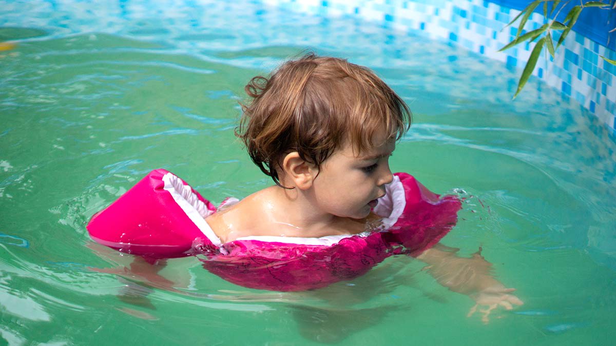 Toddler wearing a Puddle Jumper in a swimming pool.
