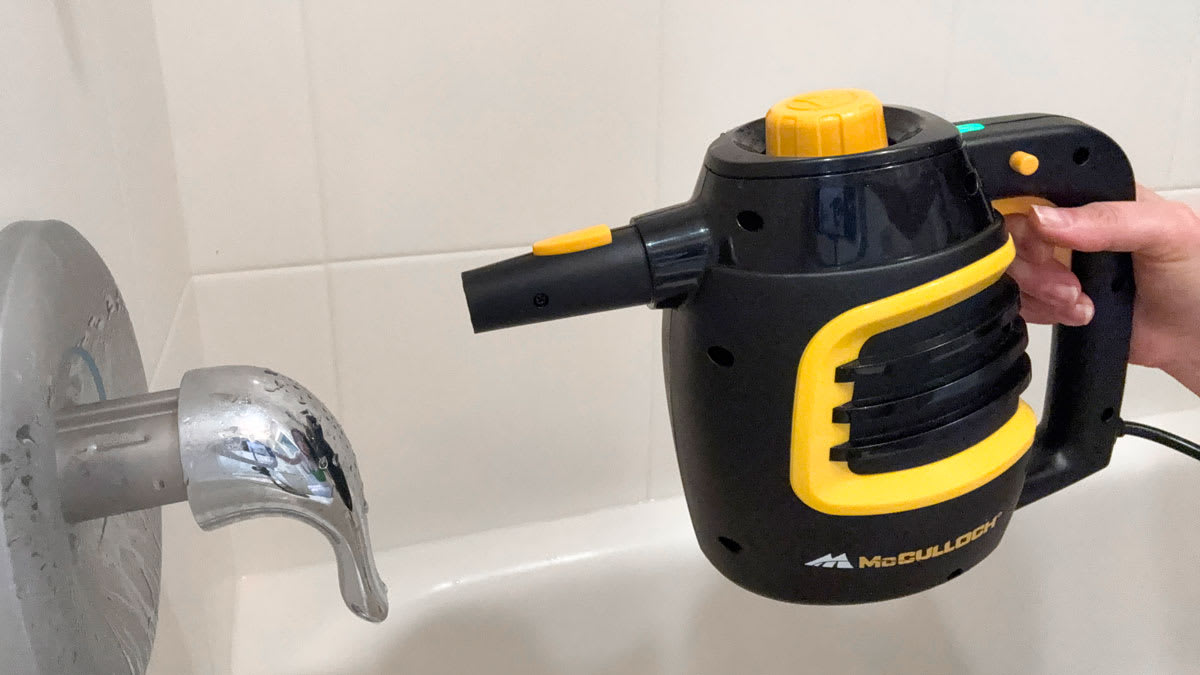 McCulloch steam cleaner cleaning a bathtub faucet