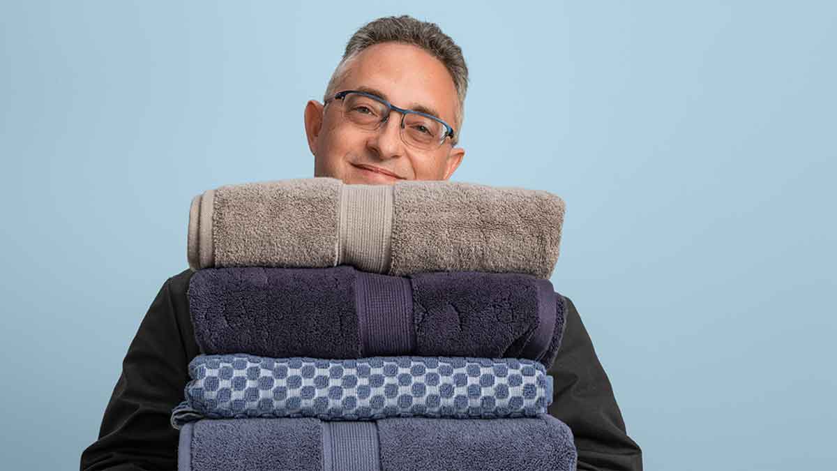 Laundry expert Rich Handel holding a stack of freshly washed and folded towels.