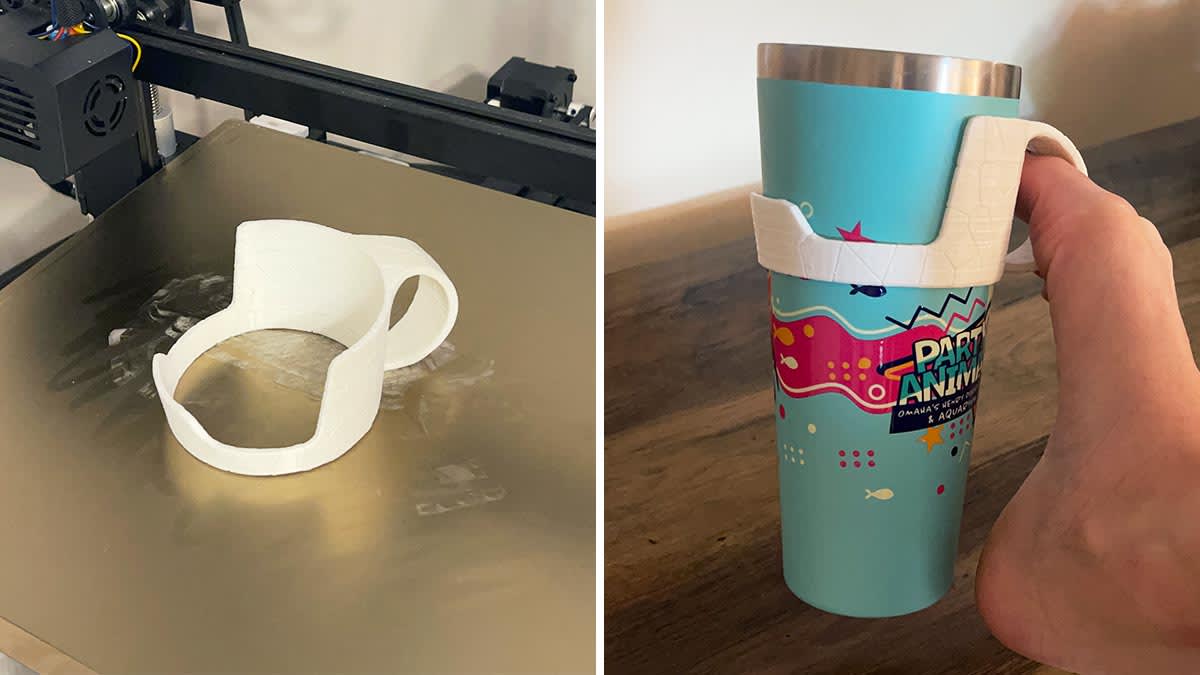 An adaptive cup holder sitting on the 3D printer and a foot using the printed cup holder to hold a insulated cup.