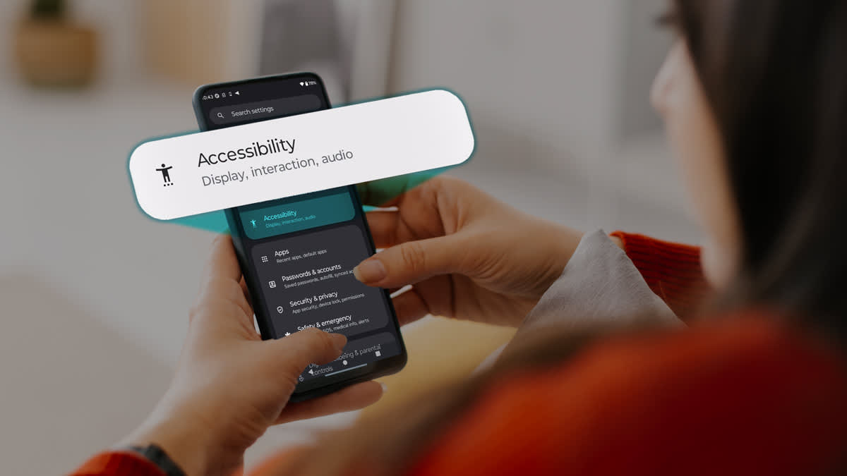 A person holding a smart phone with the settings screen open, showing the Accessibility tab.
