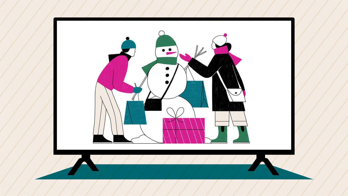 Two people building a snowman with shopping bags and gifts, shown on a large television screen.