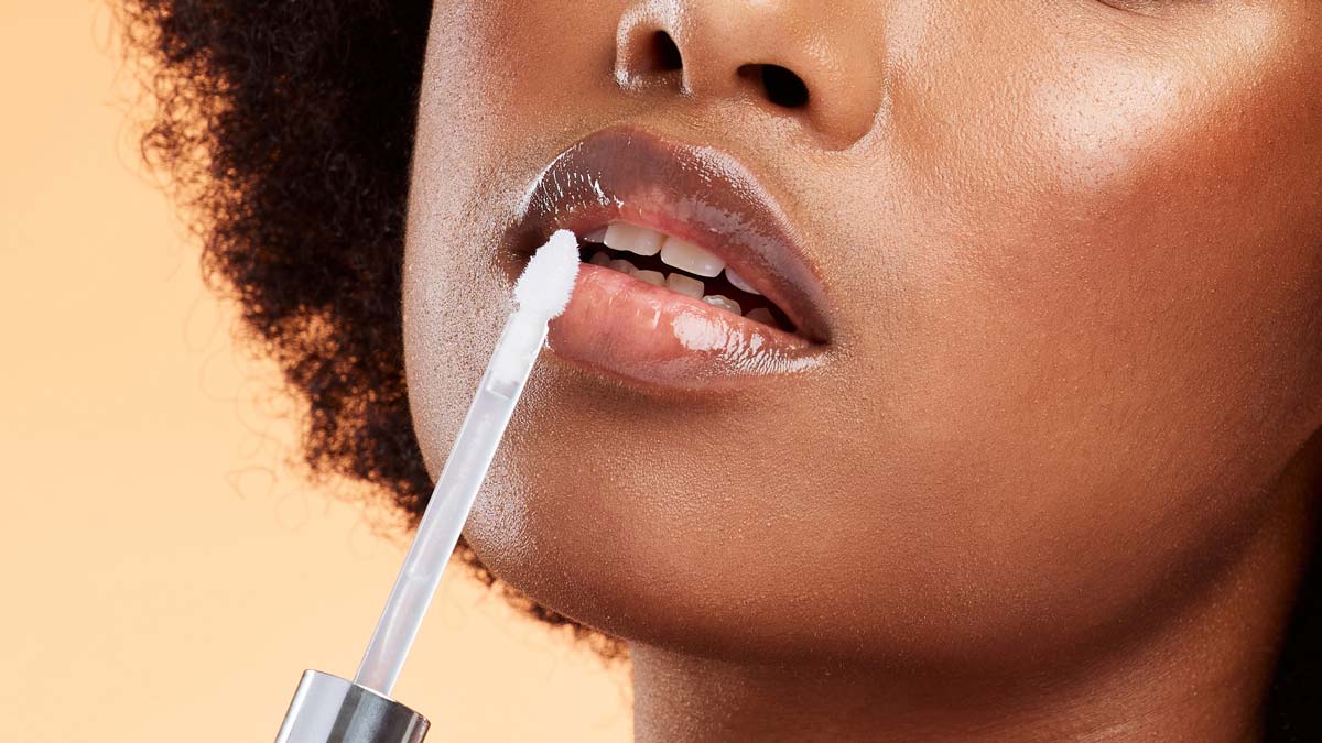Woman applying lip gloss