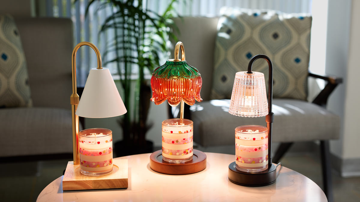SpaRoom Candle Lamp Warmer, TK, and TK on coffee table with chairs, throw pillows, and plant in background