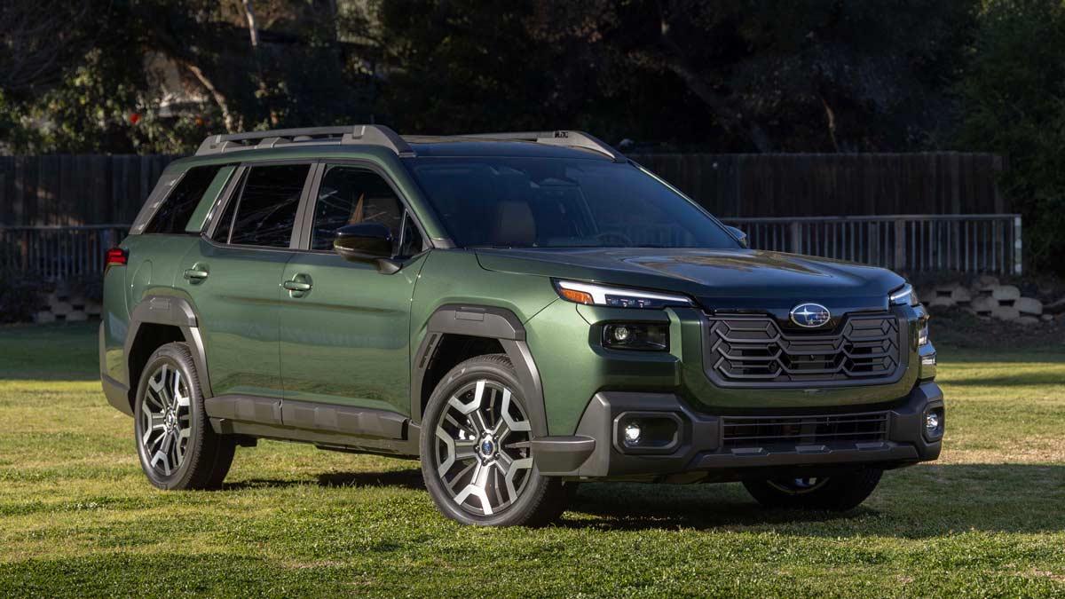 green 2026 Subaru Outback on grass with fence and trees in background