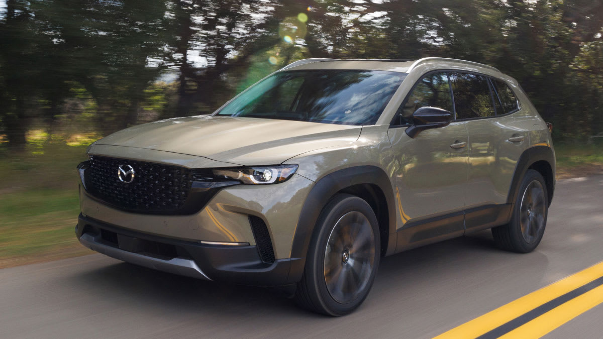 2026 Mazda CX-50 driving on a tree-lined road